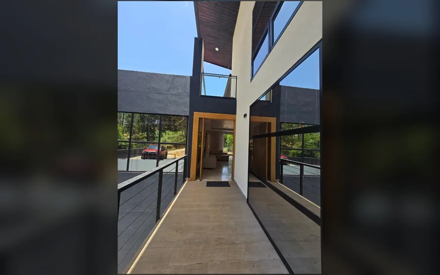 Entrada exterior con cristales, balcon y terminaciones modernas