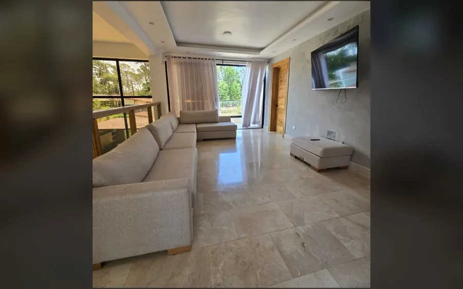 Sala familiar con sofa amplio, television y salida al balcon