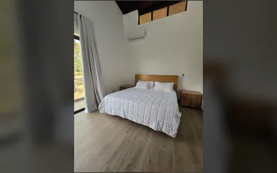 Habitacion luminosa con techo alto y ventanal hacia el exterior