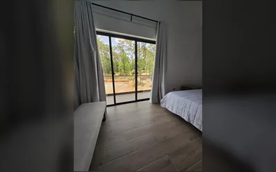 Habitacion con ventanal amplio y salida hacia balcon o terraza