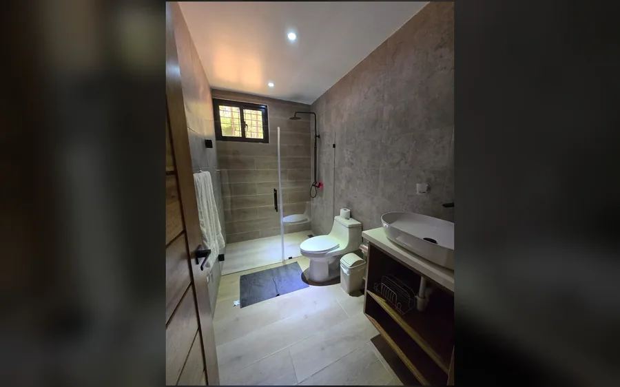 Bano completo con ducha, lavabo y revestimiento contemporaneo
