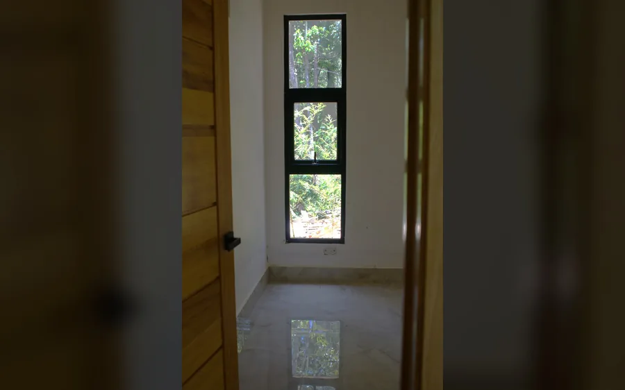 Ventana interior con vista verde en villa duplex de Jarabacoa - unidad B
