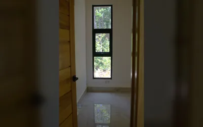 Ventana interior con vista verde en villa duplex de Jarabacoa - unidad B