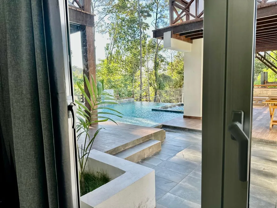 Vista desde area interior hacia piscina, jacuzzi y terraza exterior