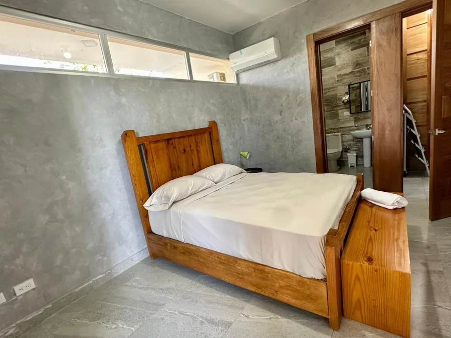 Habitacion con aire acondicionado y bano visible en villa de Jarabacoa