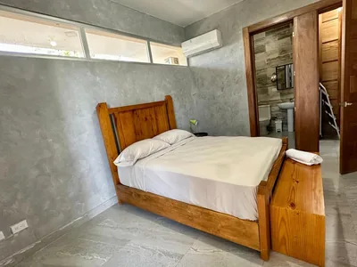 Habitacion con aire acondicionado y bano visible en villa de Jarabacoa