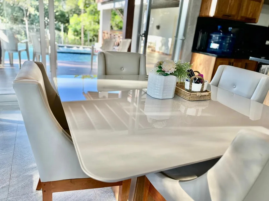 Detalle del comedor con cocina al fondo y vista hacia el area de piscina