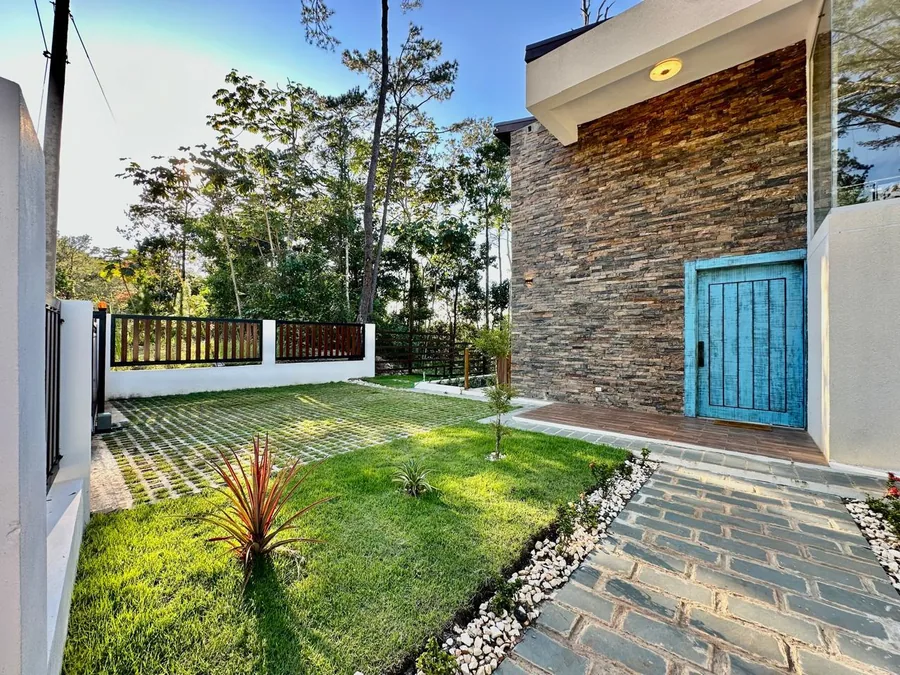 Entrada exterior con puerta azul, jardin y muro de piedra