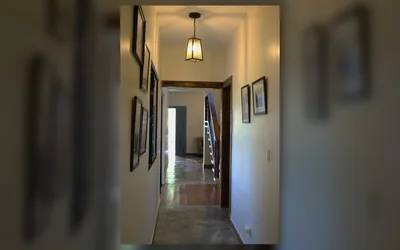 Pasillo interior de villa amoblada con luz calida y terminaciones en madera